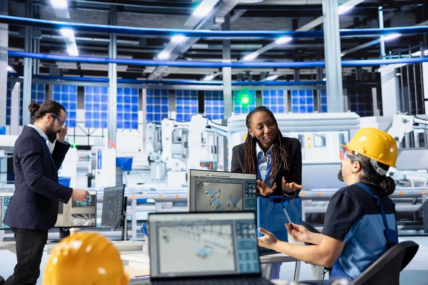 An engineering team at a solar panel plant conducting quality control using a computer.
