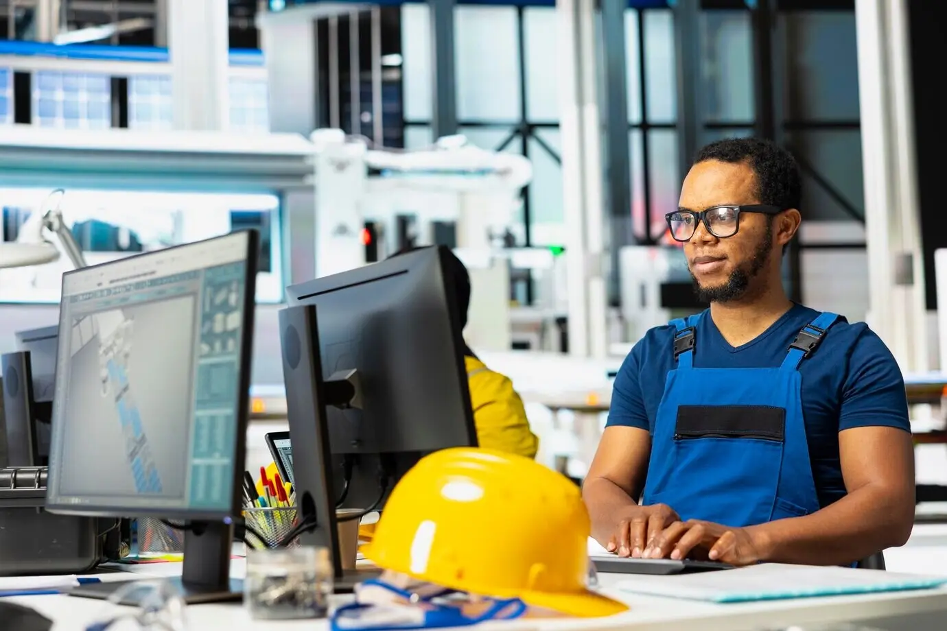 An African American supervisor fine-tuning energy control systems on an office PC